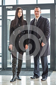 Man and woman in a coat stand near door photo
