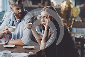 Man and woman with coffee in messy room