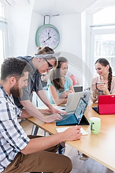 Man and woman cooperating as co-workers in collaborative office