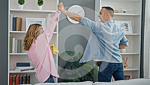 Man and woman couple cleaning shelving high five at home