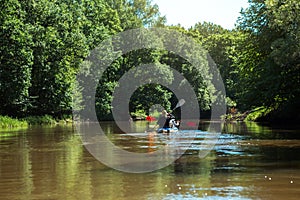 Man and woman couple in family kayak trip rowing boat on the river, a water hike, a summer adventure. Eco-friendly and extreme