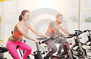 Man and woman, couple in gym on exercise biles