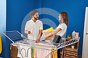 Man and woman couple hanging clothes on clothesline at laundry room