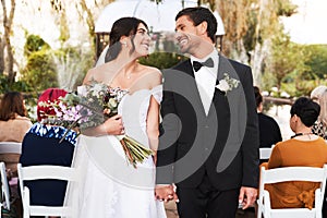 Man, woman and couple holding hands at wedding ceremony with flower bouquet, marriage or celebration. Bride, groom and