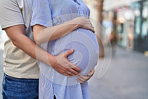 Man and woman couple hugging each other expecting baby at street