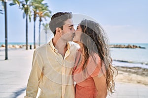 Man and woman couple hugging and kissing each other at seaside