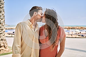 Man and woman couple hugging and kissing each other at seaside