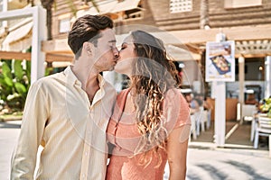 Man and woman couple hugging and kissing each other at street