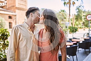 Man and woman couple hugging and kissing each other at street