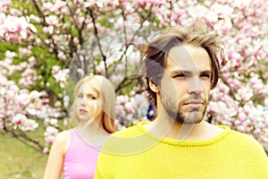 Man and woman, couple in love in spring magnolia flowers