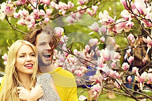 Man and woman, couple in love in spring magnolia flowers