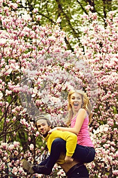 Man and woman, couple in love in spring magnolia flowers