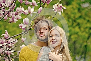 Man and woman, couple in love in spring magnolia flowers