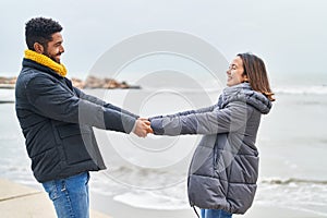 Man and woman couple smiling confident dancing at seaside