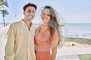 Man and woman couple smiling confident and hugging each other at seaside