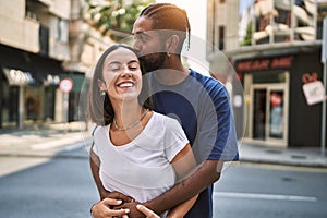 Man and woman couple smiling confident hugging each other at street