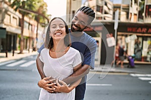 Man and woman couple smiling confident hugging each other at street