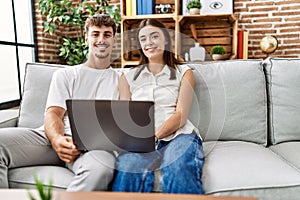 Man and woman couple smiling confident using laptop at home