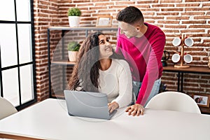 Man and woman couple smiling confident using laptop at home