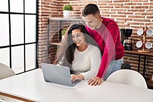 Man and woman couple smiling confident using laptop at home