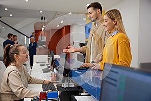 Man and woman couple talking to receptionist at family clinic center