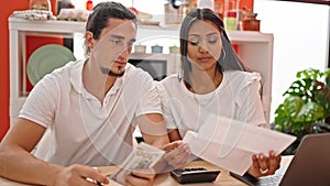 Man and woman couple using laptop accounting at dinning room