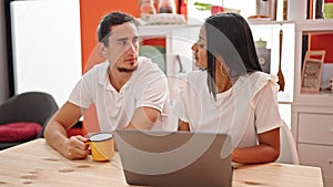 Man and woman couple using laptop drinking coffee at dinning room