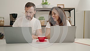 Man and woman couple using laptop teleworking at home