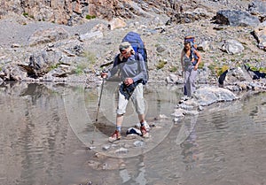 Man and woman crossing mountain river