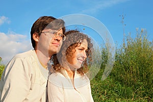 Man and woman is cuddling in sunny meadow