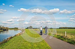 Man and woman cycle on a bike path at the top of a