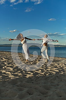 Man and woman dancing, couple happy on vacation. Couple in love running on beach, seashore. Couple in love holds hands