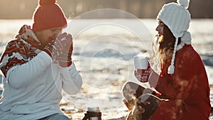 Man and woman on date meeting christmas. Young couple in love kiss in first snowy winter day and drink tea. Happy people