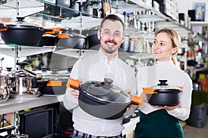 Man and woman demonstrate saucepans