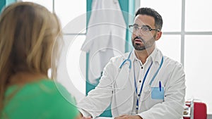 Man and woman doctor having medical consultation speaking with patient at the clinic