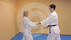 Man and woman doing Aikido in gym.