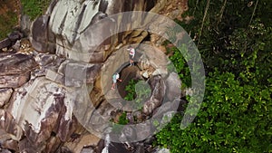 Man and woman are doing mountaineering holding the cord filmed by drone