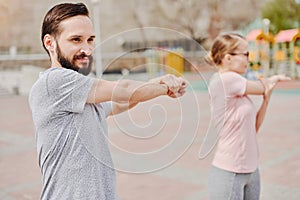 Man and woman doing warm up exercises on the street