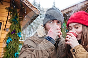 Man and woman drinking hot coffee on christmas market