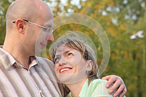 Man and woman in early fall park.