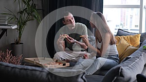 Man and woman eat pizza at home. Ready meal delivery concept. Fast food