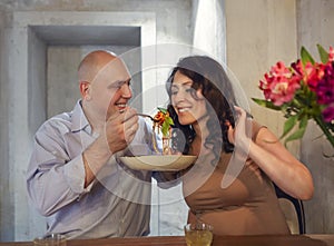 Man and woman eating bolognese spaghetti in restorant