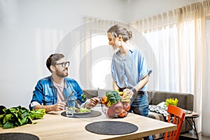 Man and woman eating healthy food at home