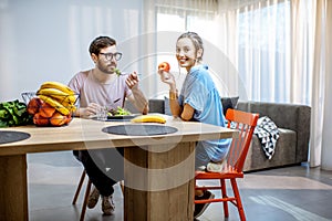 Man and woman eating healthy food at home