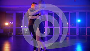 A man and woman elegantly tangoing at a lively party. Two dancers caught in the passion of the kizomba.