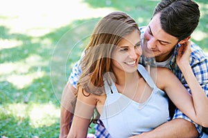 Man, woman and embrace on grass in park for holiday bonding in summer for relax, partnership or love. Happy couple, hug