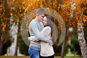 Man and woman embracing in autumn park