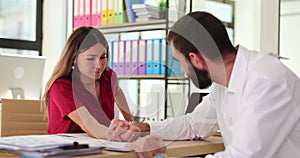 Man and woman are engaged in arm wrestling in office