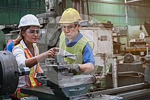 Man and woman engineer industry worker wearing hard hat in factory