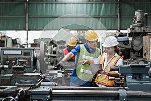 Man and woman engineer industry worker wearing hard hat in factory.